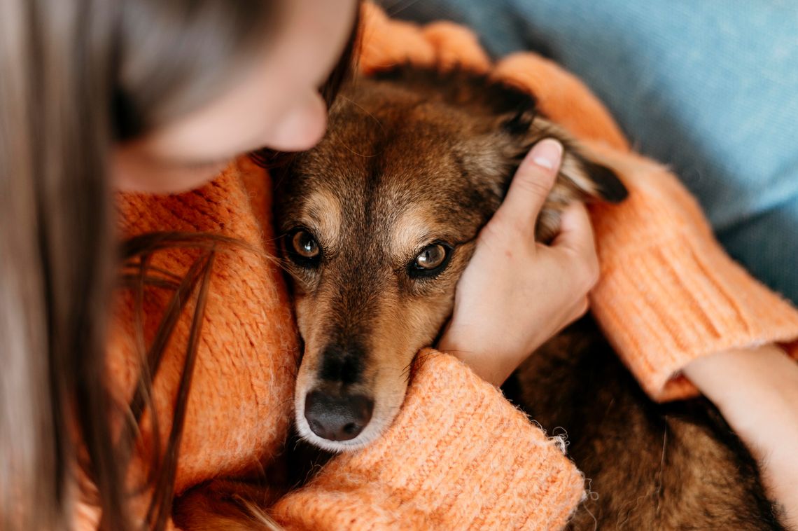 Woman holding her dog in her lap
