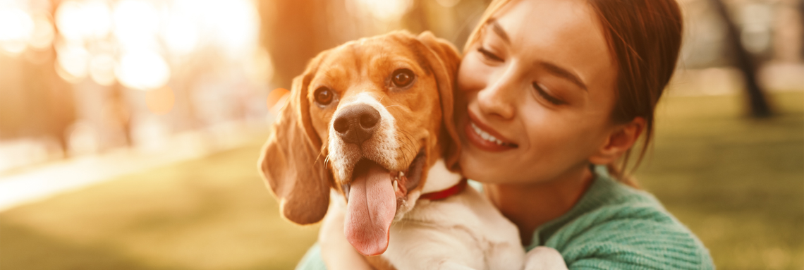 woman smiling holding happy puppy
