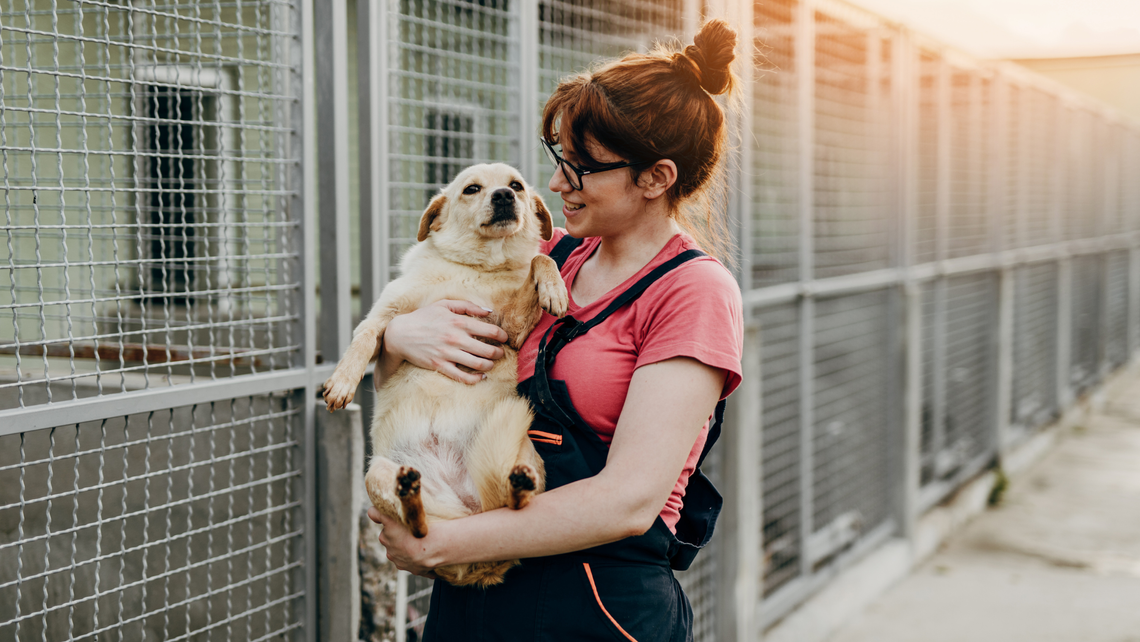 woman holding dog outside animal shelter